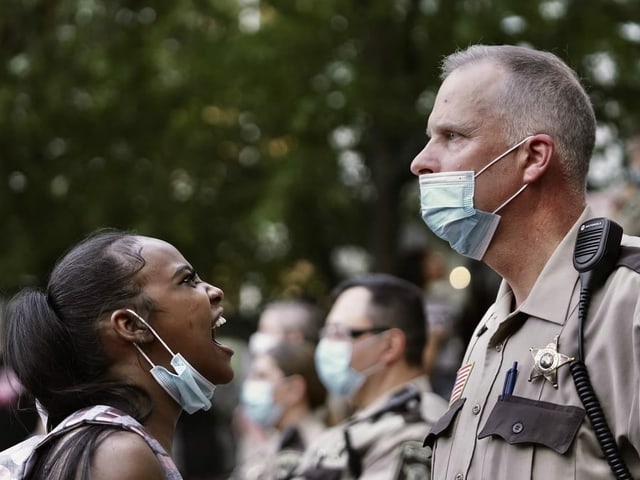 Demonstrantin in Minnesota bringt ihre Wut zum Ausdruck gegen einen Polizeioffizier.