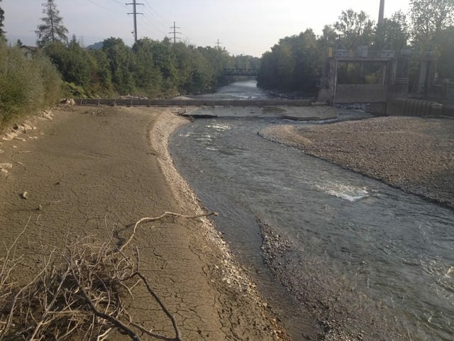 Fluss mit neuer, breitem Hochwasserschutz.