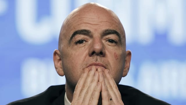 Giani Infantino hält sich die Hände ans Kinn und studiert. Man sieht  nur seinen Kopf.