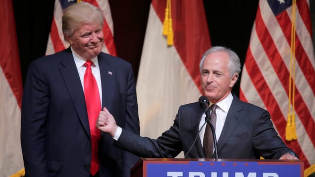 Corker an Rednerpult, Trump steht daneben, dahinter US-Flaggen.