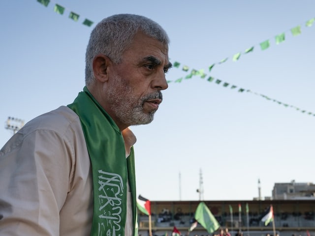 Ein älterer Mann mit weissen Haaren und einem Hamas-Schal