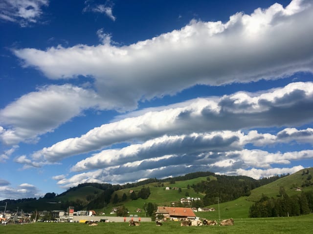 Wolken wie Bänder, schweben über der Stadt, es herrscht denoch recht sonniges Wetter.