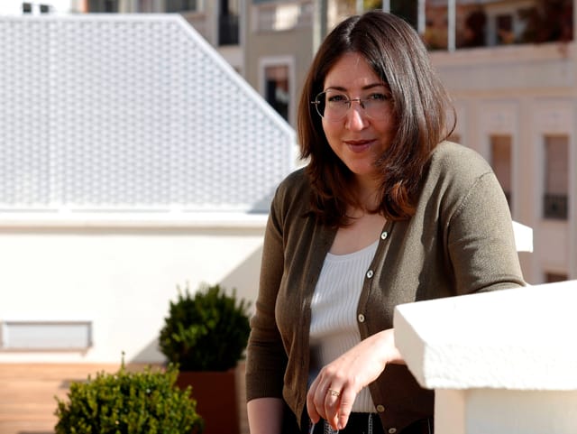 Deborah Feldman sitzt auf einer Terrasse im Sonnenlicht.