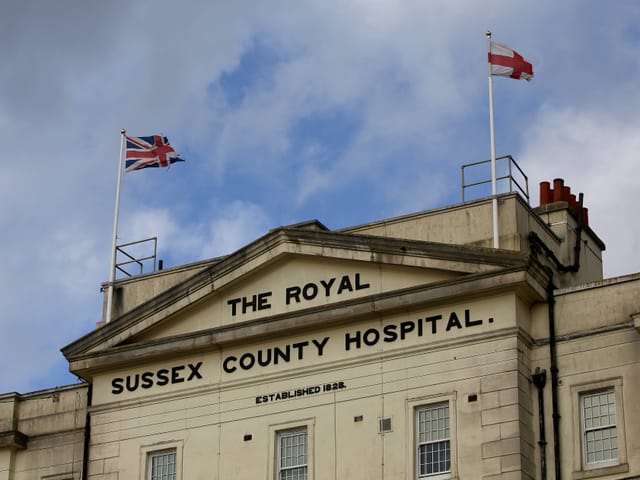 Fassade des Royal Sussex County Hospital mit britischen Flaggen.