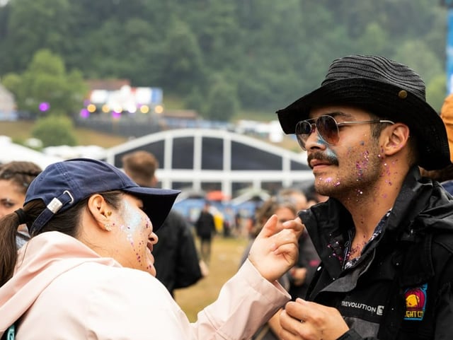 Zwei Menschen am Openair St. Gallen, beide mit Glitzer im Gesicht