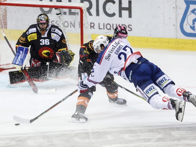 Eishockeyspieler im Zweikampf vor Torwart.