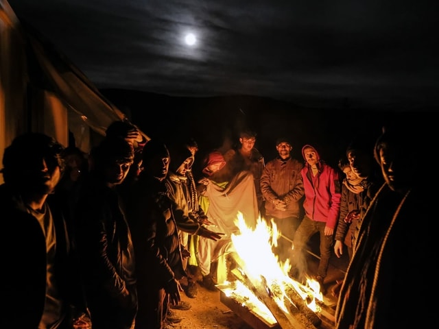 Men gather around a fire