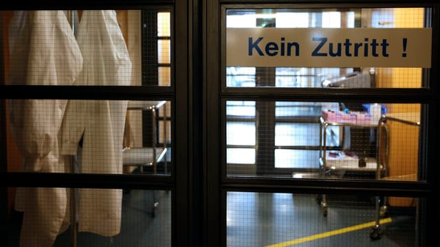 Blick auf eine geschlossene Schiebetür mit dem Schild «Kein Zutritt!», dahinter Medizinalausrüstung.