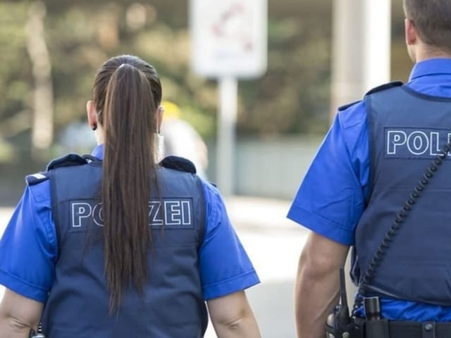 Eine Frau und ein Mann in blauer Polizeiuniform.