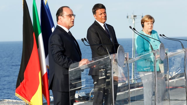 François Hollande, Matteo Renzi und Angela Merkel sprechen an einer Medienkonferenz auf einem Flugzeugträger vor der italienischen Insel Ventotene. (reuters)