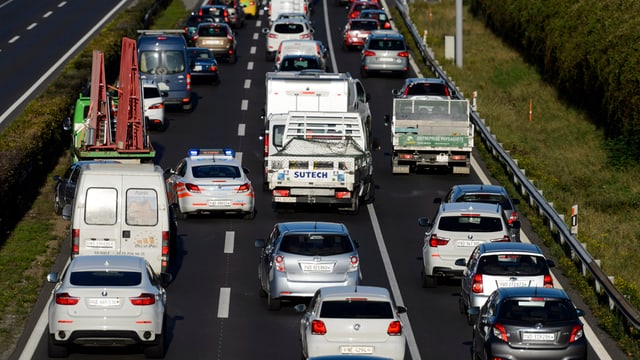 Autobahn mit 3 Spuren in eine Richtung und vielen Autos (Stau)