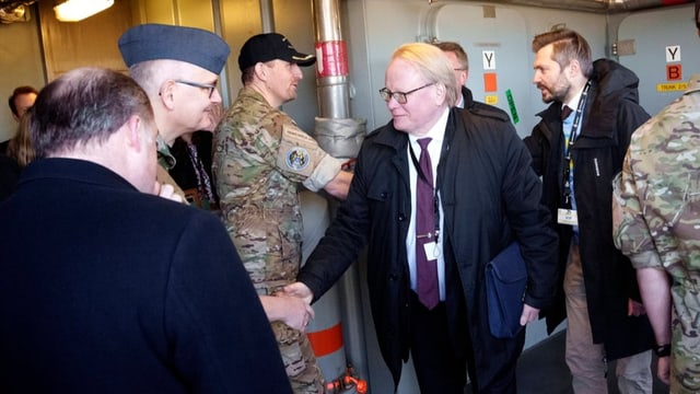 Hultqvist schüttelt die Hand eines Uniformierten.