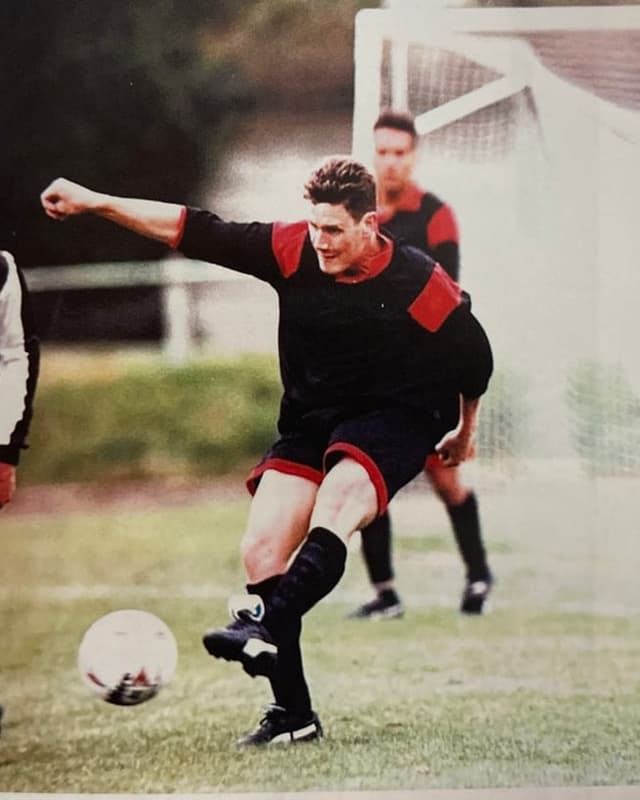 Fussballspieler tritt den Ball auf dem Spielfeld.