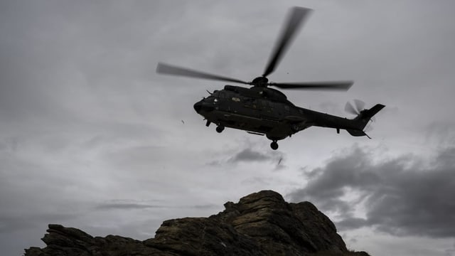 Ein Super Puma fliegt über den Schweizer Alpen.