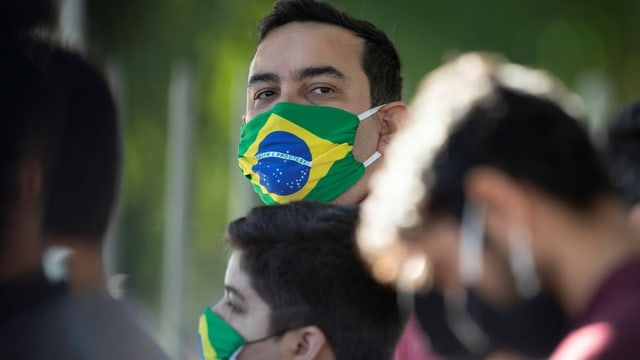 A man in a mask with the flag of Brazil