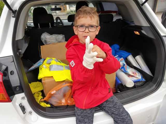 Junge zieht sich Plastikhandschuhe an