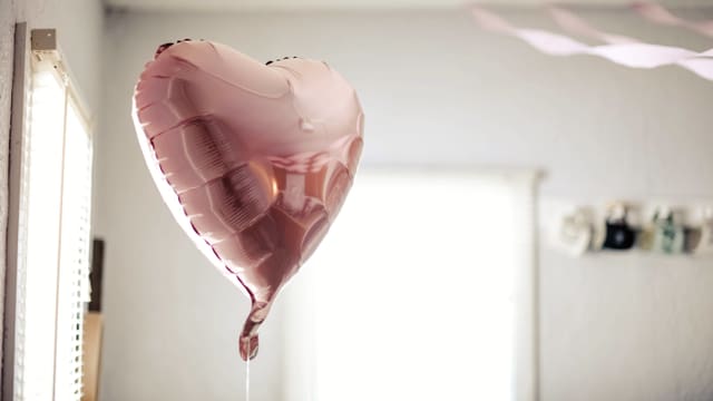 Ein rosa, herzförmiger Ballon.