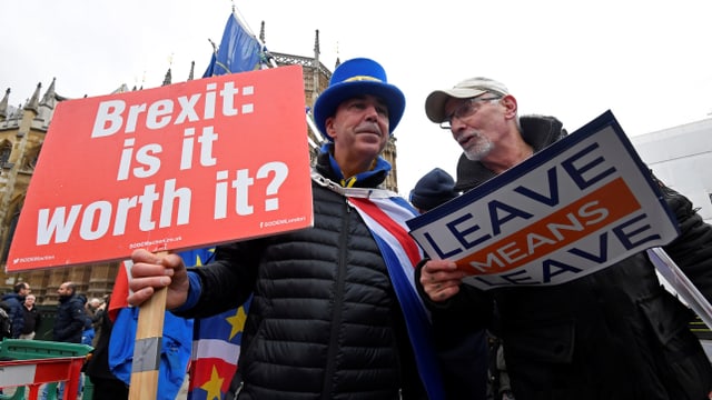 Zwei Männer mit zwei Plakaten pro und kontra den Brexit.