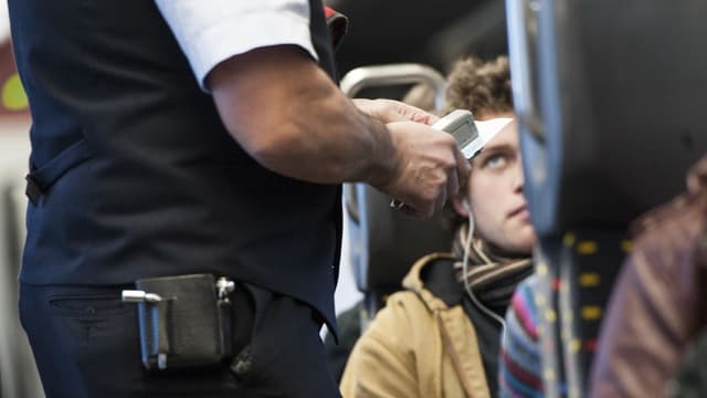 Ein Mann zeigt sein Ticket im Zug.