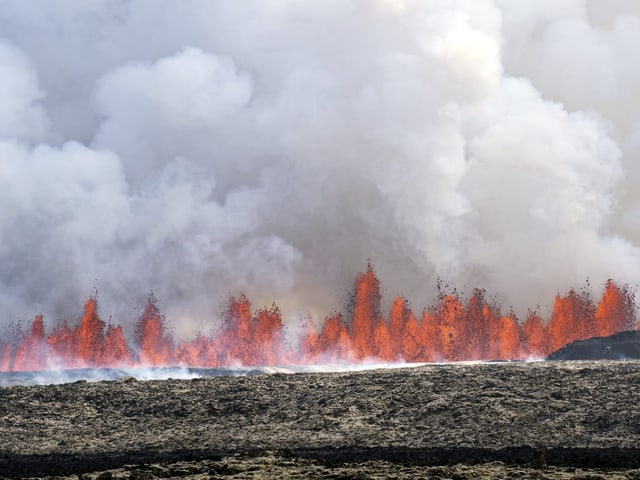 Rote Lavafontänen und Rauch am Himmel.