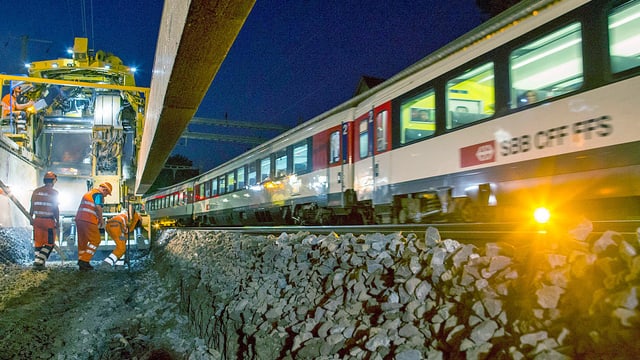 Zug fährt an Baustelle vorbei.