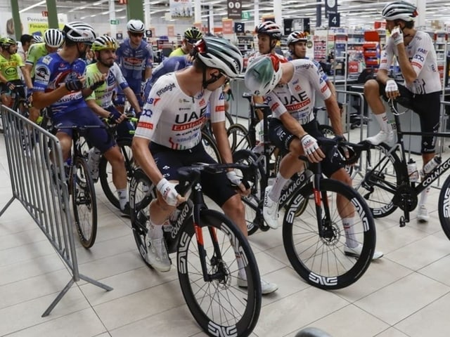 Rennradfahrer im Supermarkt beim Aufwärmen.