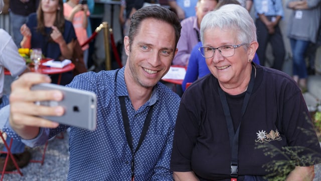 Adrian Küpfer macht ein Selfie mit einer Besucherin.