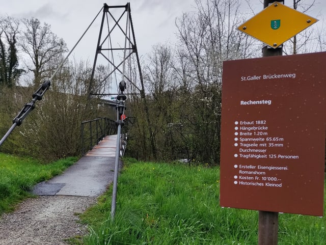 Hinweisschild bei kleiner Hängebrücke.