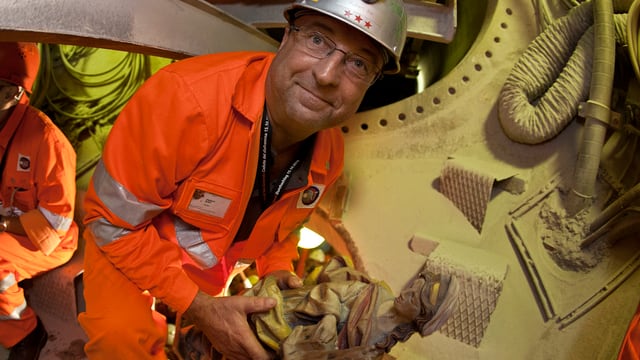 Miner Hubert Baer, carrying the Saint Barbara, patron saint of the miners, is climbing through the cutterhead, shortly after the breakthrough of the Gotthard Base Tunnel near Faido, Switzerland, Friday, October 15, 2010. (KEYSTONE/Martin Ruetschi) Mineur Hubert Baer traegt am 15. Oktober 2010 eine Statue der Heiligen Barbara, waehrend er durch den Bohrkopf steigt, kurz nach dem Durchstich des Gotthardbasistunnels, bei Faido im Kanton Tessin, Schweiz. (KEYSTONE/Martin Ruetschi)