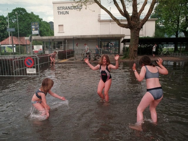 Kinder spielen im überschwemmten Bereich vor dem Strandbad Thun