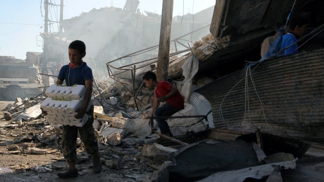 Zwei Kinder sichern Ware nach einem Luftangriff in Atareb in der Provin Aleppo. 