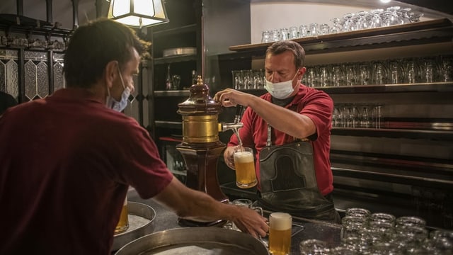 Ein Wirt an einem Bier-Zapfhahn.