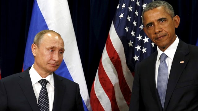 Putin und Obama stehen nebeneinander vor ihren Landesflaggen, beide blicken wenig begeistert in die Kamera.