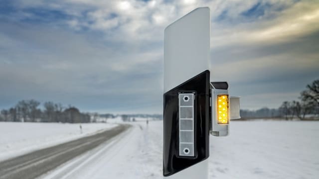 Strassenpfosten mit kleinem blinkenden Kästchen.