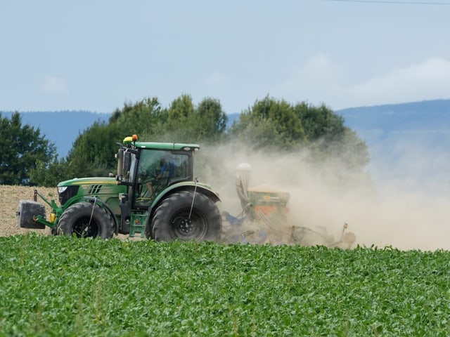 Ein Traktor wirbelt Staub auf