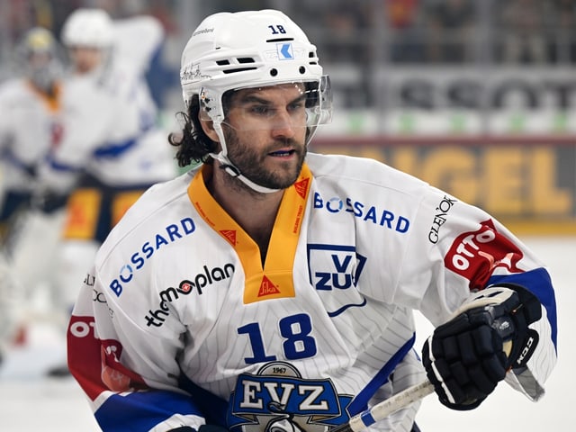 Eishockeyspieler im Spiel mit weissem Trikot.