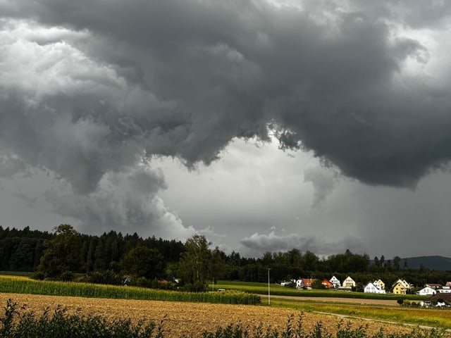 Dunkle Wolken über einem ländlichen Dorf.