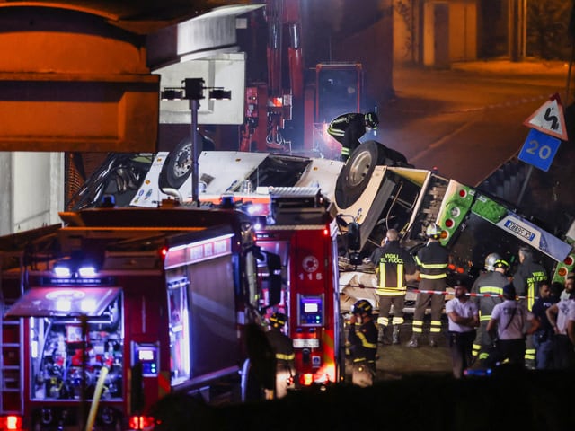 Feuerwehrleute stehen vor dem verunglückten Reisebus.