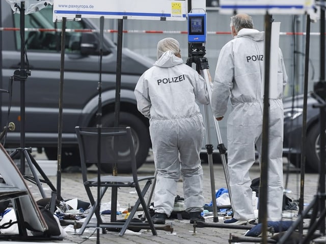 Polizei in Schutzkleidung an einem Tatort.