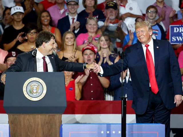 Balderson reicht Trump auf Podium die Hand.