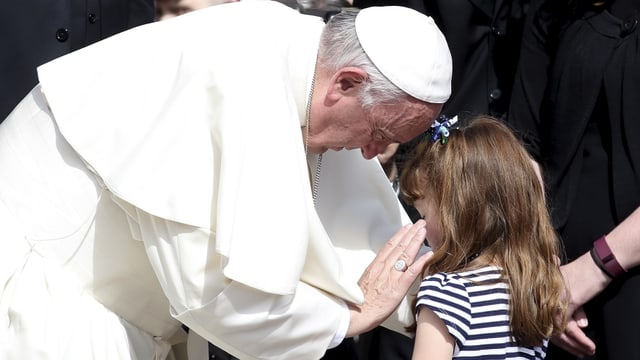 Der Papst spricht mit einem Mädchen.