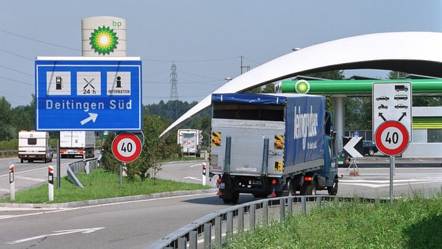 Ein Lastwagen fährt auf eine Autobahnraststätte.