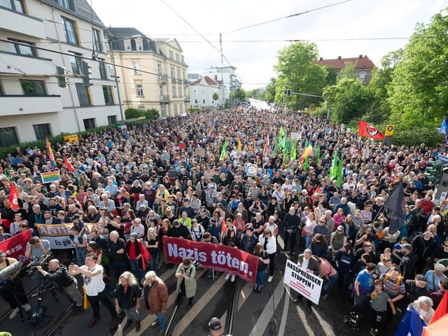 Grosse Menschenmenge bei einer Demonstration auf einer städtischen Strasse.