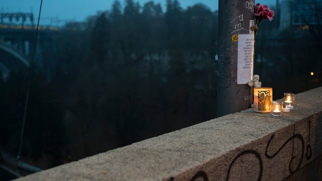 Kerzen und Blumengesteck auf einer Brücke