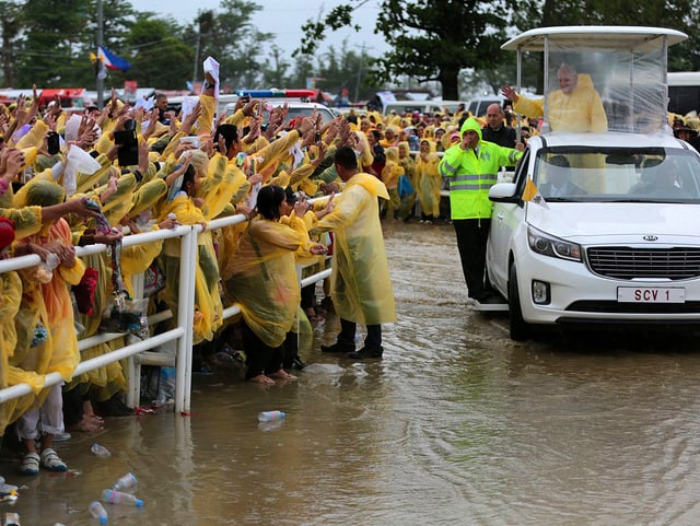 Papst im Papamobil im Regen