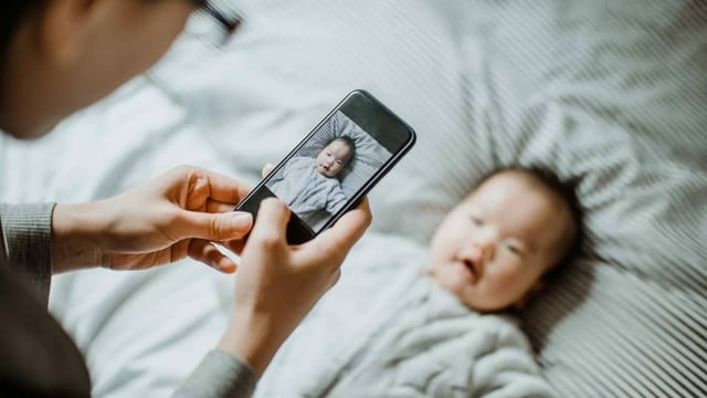 Eine Mutter macht ein Foto von ihrem Baby