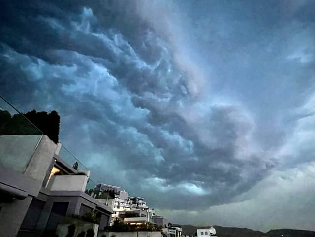 Gewitterwolken während der Dämmerung über Häuserzeile