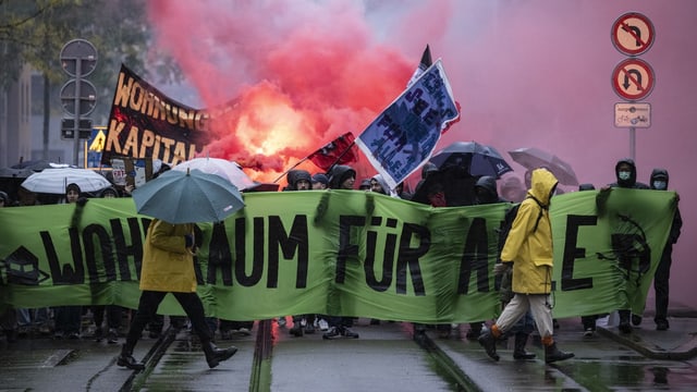 Pyros und Transparente werden von Personen hochgehalten.