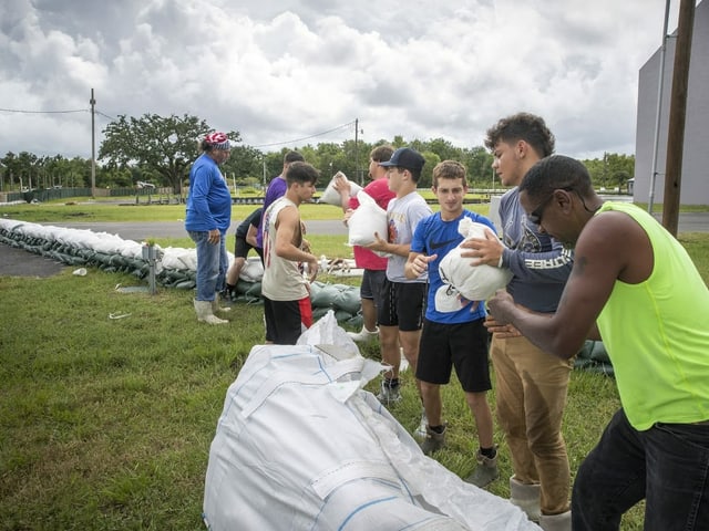 Football- und Basketballspieler der Fisher High School in einem Vorort von New Orleans helfen beim Bau eines Deichs mit Sandsäcken.