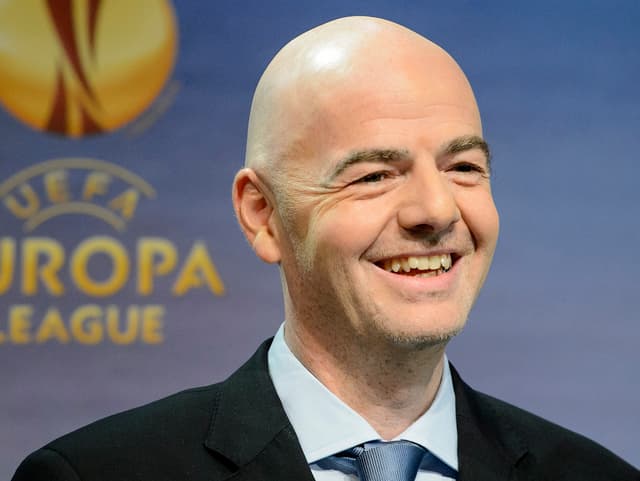 Gianni Infantino lachend vor einer UEFA-Tafel